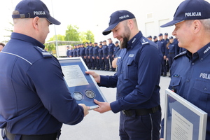 Komendant Wojewódzki Policji w Lublinie insp. Tomasz Gil wręcza pamiątkowy ryngraf Zastępcy Komendanta Centralnego Biura Zwalczania Cyberprzestępczości insp. Michałowi Pudło.