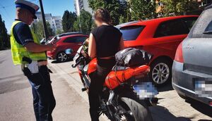 policjant podczas kontroli drogowej motocyklisty