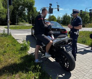 policjant podczas kontroli drogowej motocyklisty