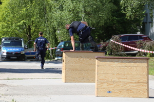 Policjanci podczas zawodów przeskakują przez skrzynię.