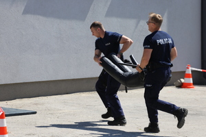 Policjanci niosą manekina.