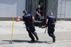 Policjanci niosą manekina.