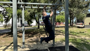 Policjant przemieszcza się po drabince nie dotykając ziemi.