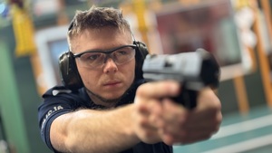Policjant strzela do tarczy strzeleckiej.