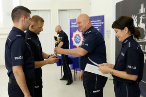 Zastępca Komendanta Wojewódzkiego Policji w Lublinie wręcza puchar funkcjonariuszom za zajęcie pierwszego miejsca w konkursie.