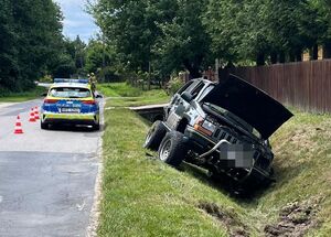 jeep w rowie, obok policyjny radiowóz