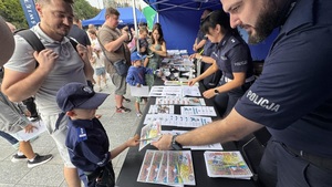 Policjant daje dziecku kolorowanki.