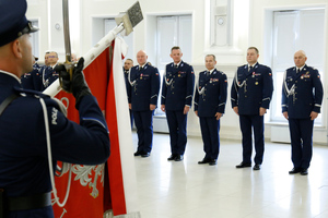 Kada kierownicza lubelskiej policji na tle sztandaru garnizonu lubelskiego.