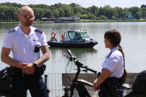 W pierwszym planie policjanci z patrolu rowerowego w drugim planie policjanci na łodzi