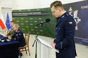 Policjant który stoi przy mikrofonie