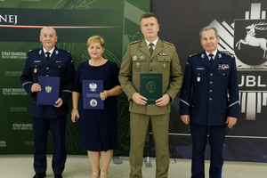 Komendant Powiatowy Policji w Janowie Lubelskim podinspektor Stanisław Niemczycki, Dyrektor Zespołu Szkół w Janowie Lubelskim, Zastępca Komendanta Nadbużańskiego Oddziału Straży Granicznej płk SG Jan Szynal i I zastępca Komendanta Wojewódzkiego Policji w Lublinie inspektor Andrzej Mioduna stoją obok siebie trzymając w podpisane porozumienie