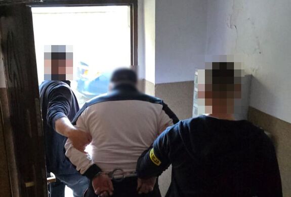 policjanci prowadzą zatrzymanego