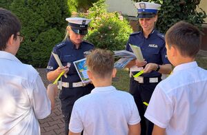 policjantki rozdają odblaski dzieciom przed szkołą