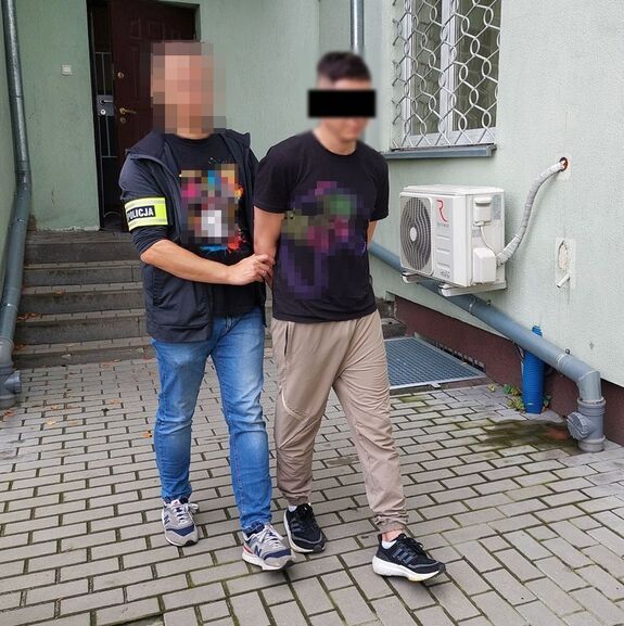 policjant prowadzi zatrzymanego