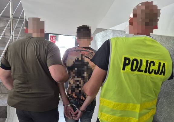 Policjanci prowadzą zatrzymanego.