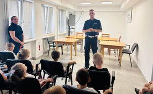 policjant rozmawia z dziećmi z grupy przedszkolnej