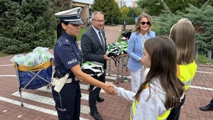 Policjantka daje dziecku kask.