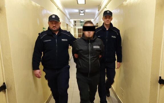 policjanci prowadzą zatrzymanego
