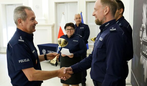 Zastępca Komendanta Wojewódzkiego Policji w Lublinie inspektor Andrzej Mioduna wręcza puchar podinspektorowi Wojciechowi Lesiukowi za zajęcie pierwszego miejsca w konkursie.
