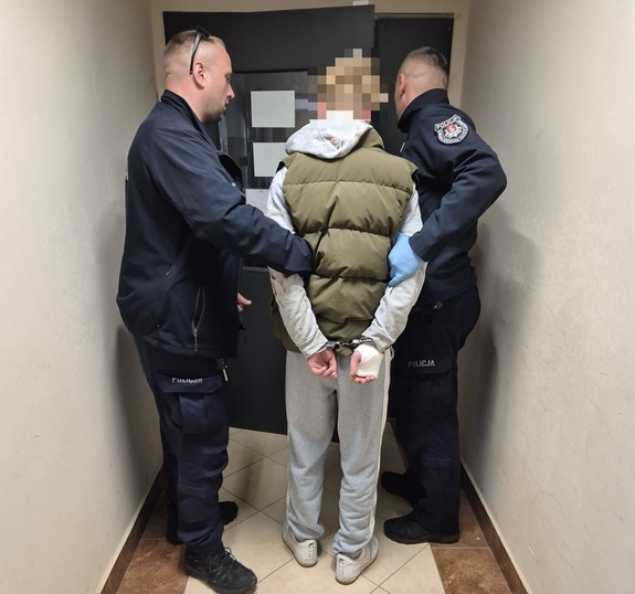 dwóch policjantów prowadzi mężczyznę