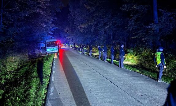 Policjanci stoją wzdłuż lasu podczas poszukiwań