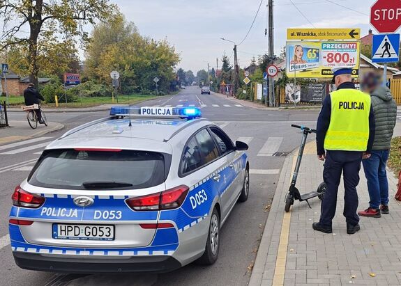 policjant kontroluję mężczyznę na hulajnodze
