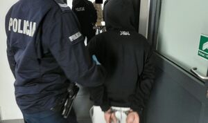 Policjanci prowadzą zatrzymanego.