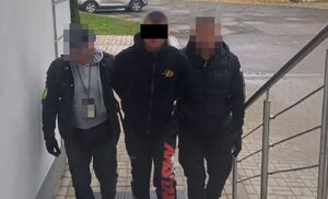 Policjanci prowadzą zatrzymanego.
