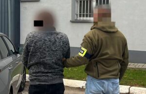 Policjanci prowadzą zatrzymanego.