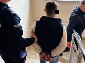 Policjanci prowadzą zatrzymanego.