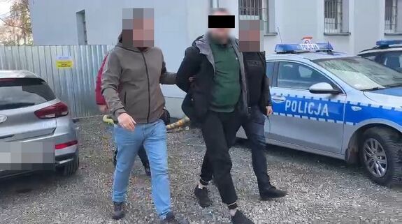 Policjanci prowadzą zatrzymanego mężczyznę