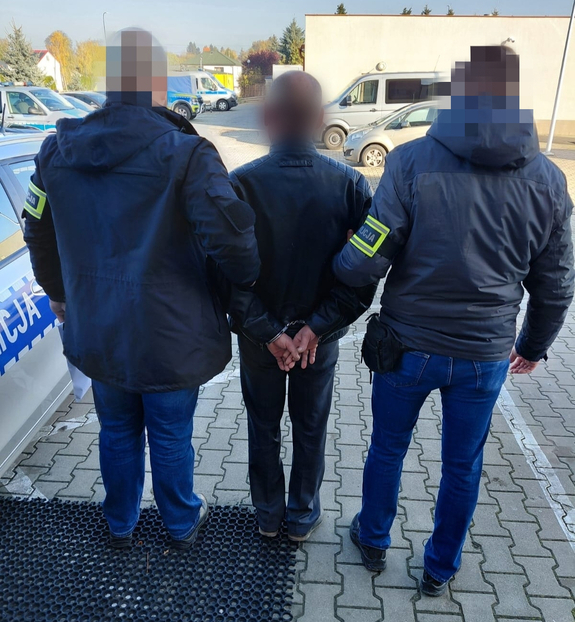 policjanci prowadzą zatrzymanego mężczyznę