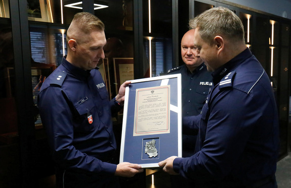 Podkomisarza Paweł Burda z rąk Komendanta Wojewódzkiego Policji w Lublinie inspektor Tomasza Gila otrzymuje pamiątkowy ryngraf.